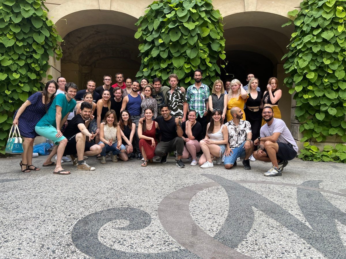 A large group of Yatin & Nikol bachata students together in a courtyard after class